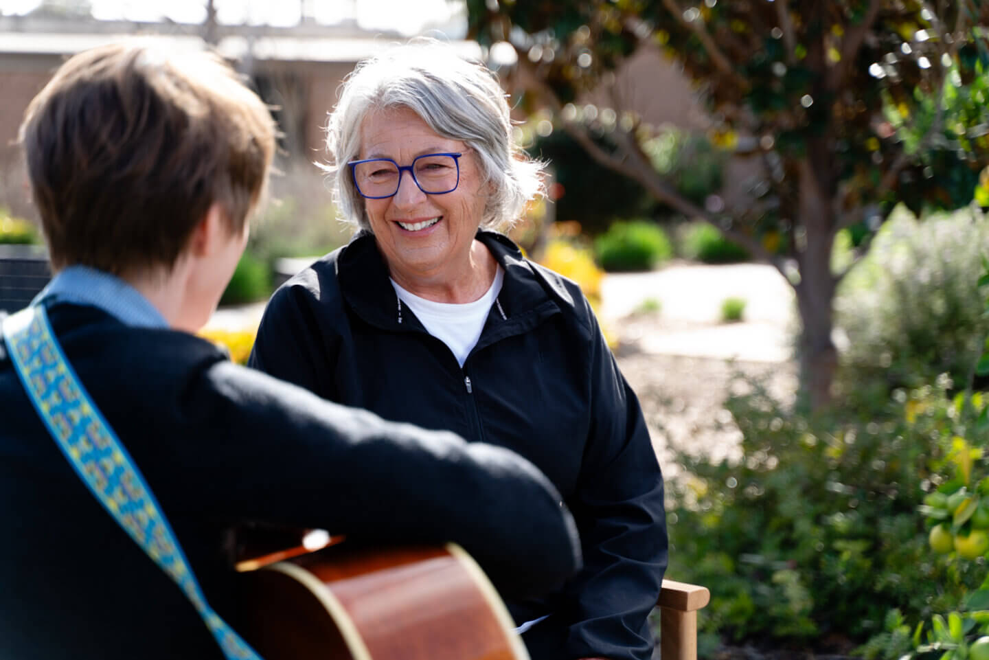 Female ECH resident receiving guitar lesson in ECH Music Therapy class.