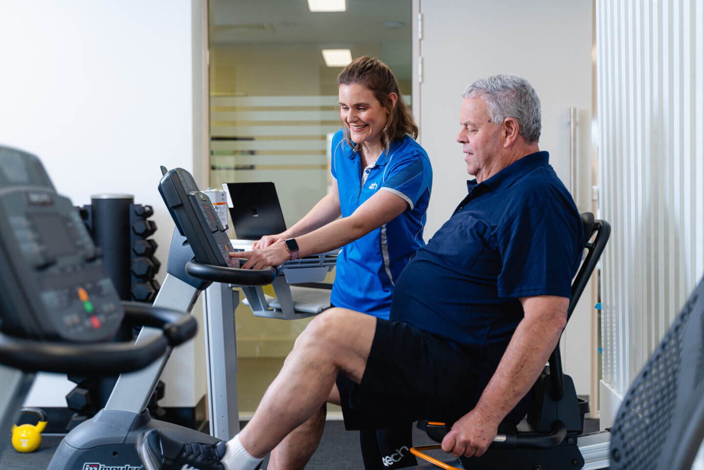 ECH resident using exercise bike in Fitness Class with personal training by Allied Health Graduates
