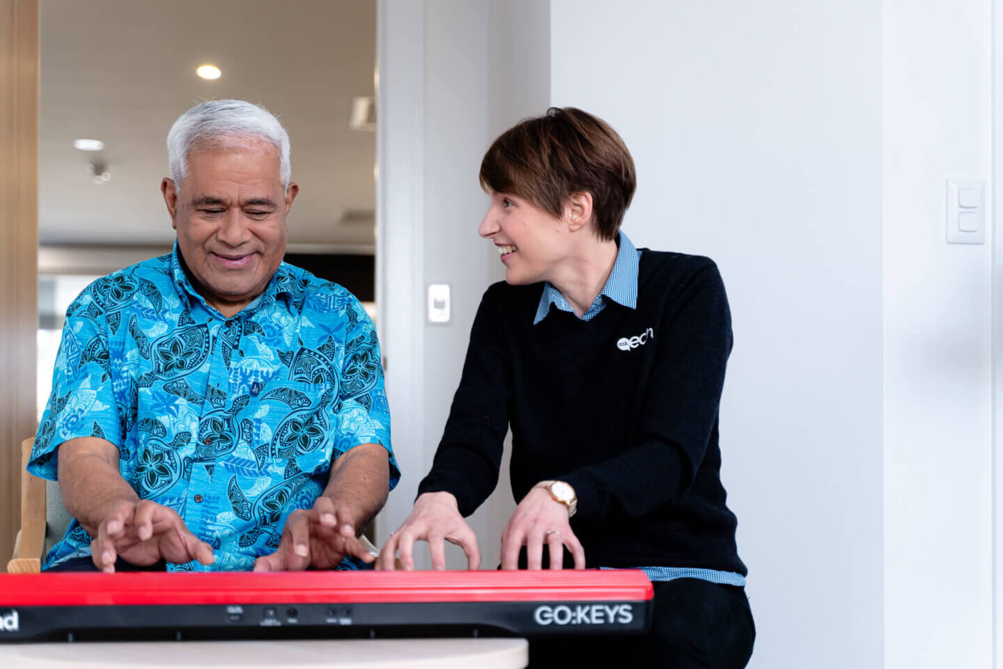 ECH resident playing piano in Music Therapy class with ECH employee